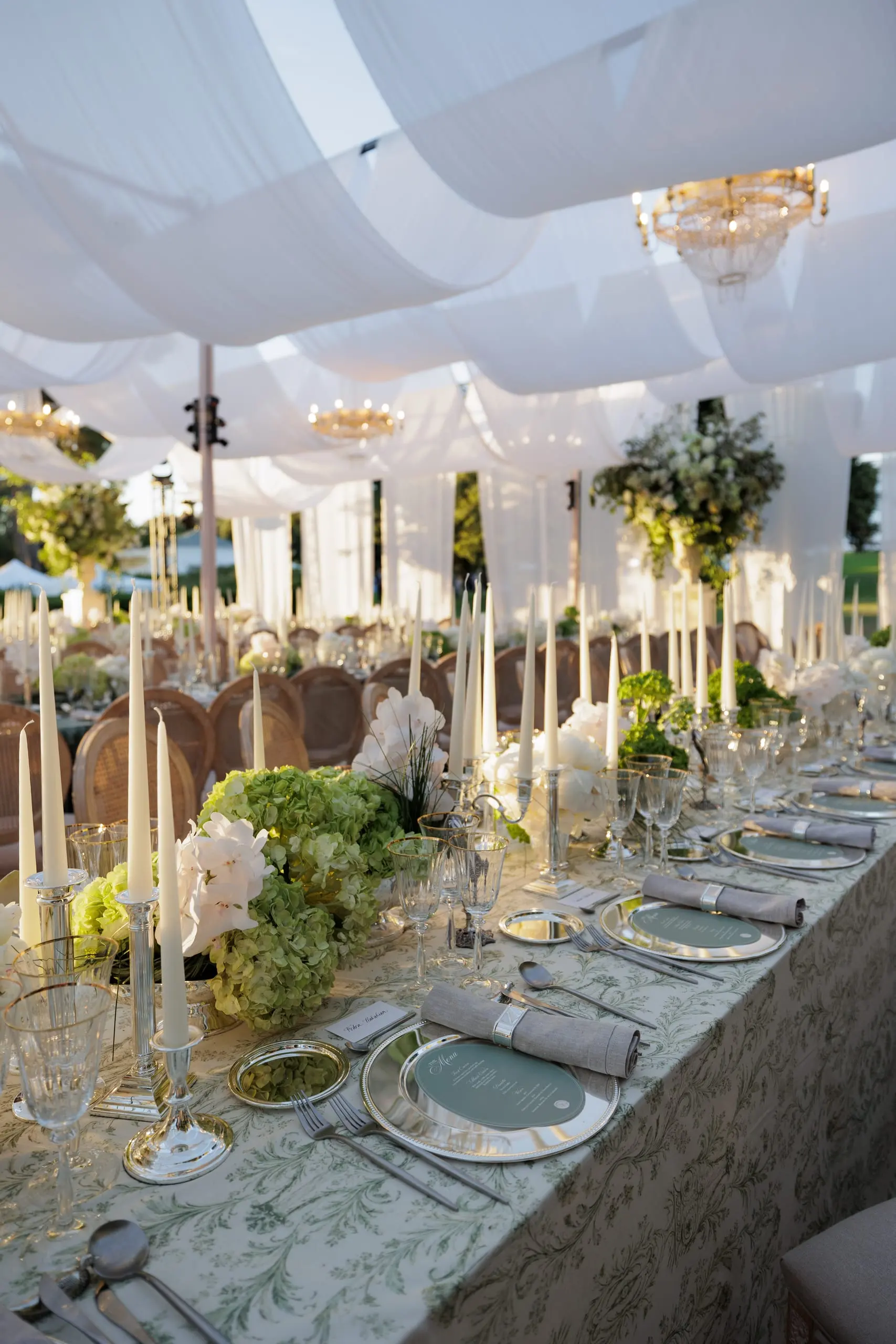 Table de mariage dressée sous des voilages blancs et des lustres, au Cap d’Antibes